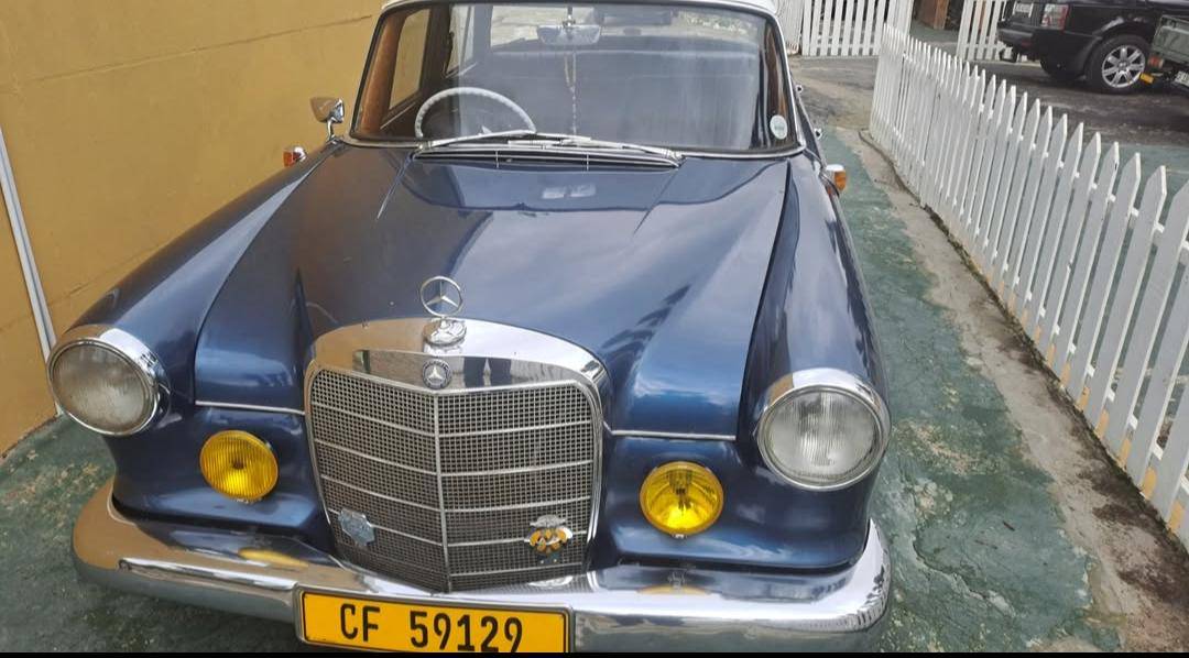 Detailed close-up of a vintage car's headlight and chrome bumper